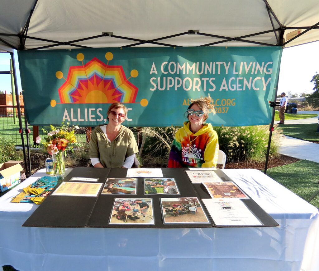 Allies LLC representatives at their table during the night showing of the Sprout Film Festival, sharing their mission and support for the disability community.